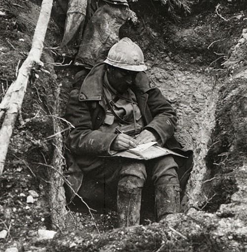 Poilu écrivant dans une tranchée